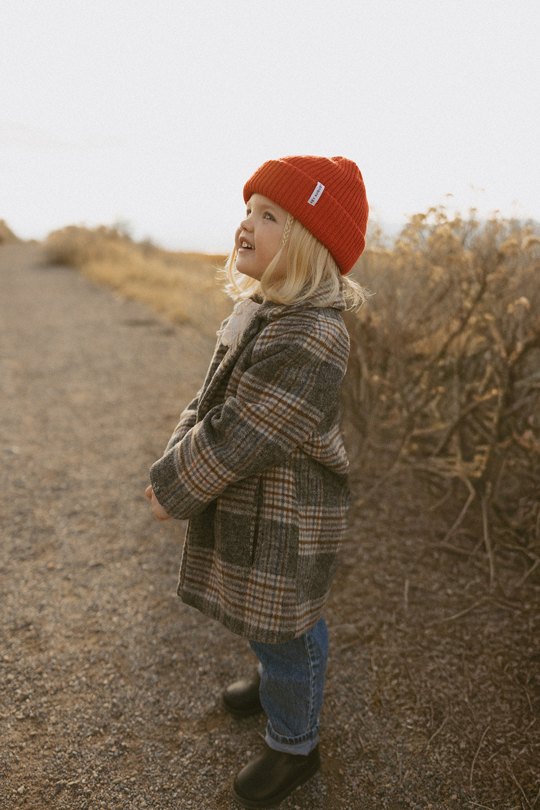 Child playing outdoors wearing Hey August gear