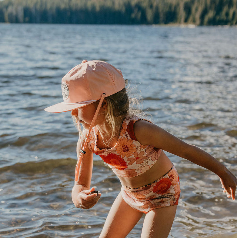 Child wearing a mustard five-panel cap